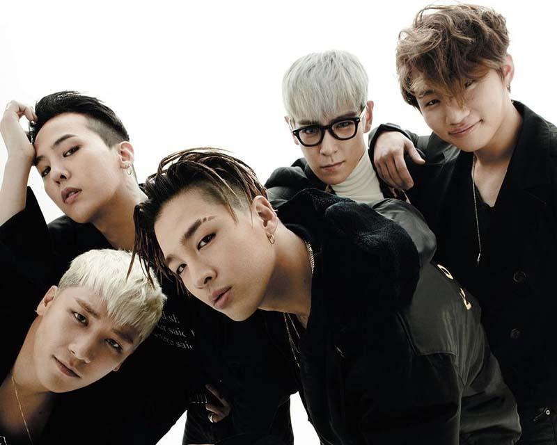 一組韓國男團的合照，成員們身穿襯衫和西服，坐或站在一起，呈現團結氛圍。