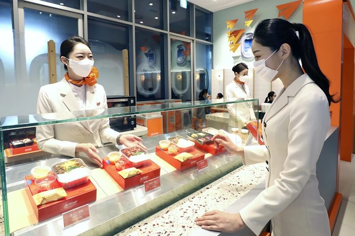 空服員在濟州航空快閃店內展示機內餐點,弘大AK Plaza