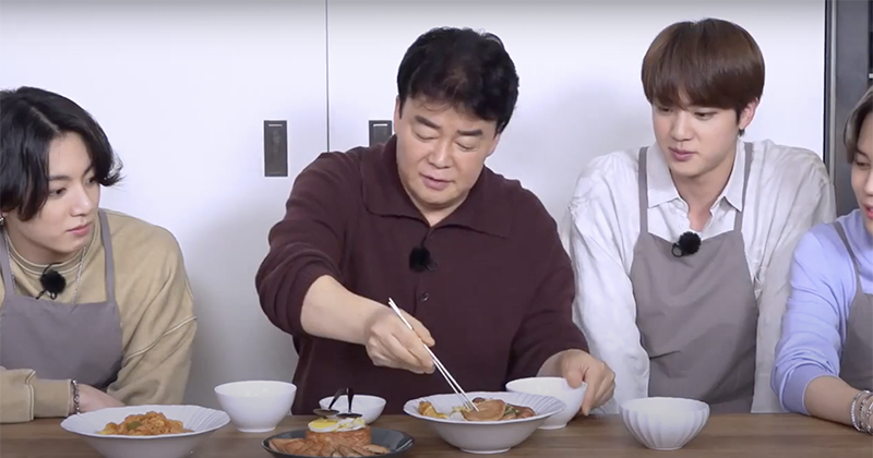 Baek Jong-won about to use his chopsticks to taste food made by the members of BTS