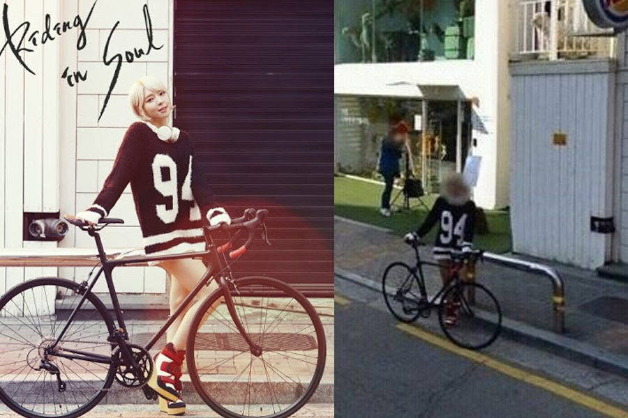 騎自行車的時尚女子站在街上，背景為白牆和透明玻璃入口。