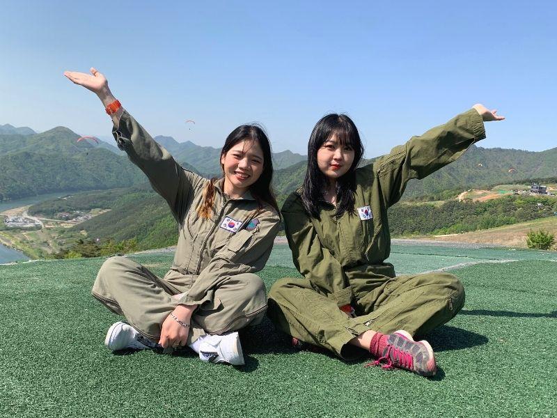 two girls sitting in a mountain Paragliding at Danyang 