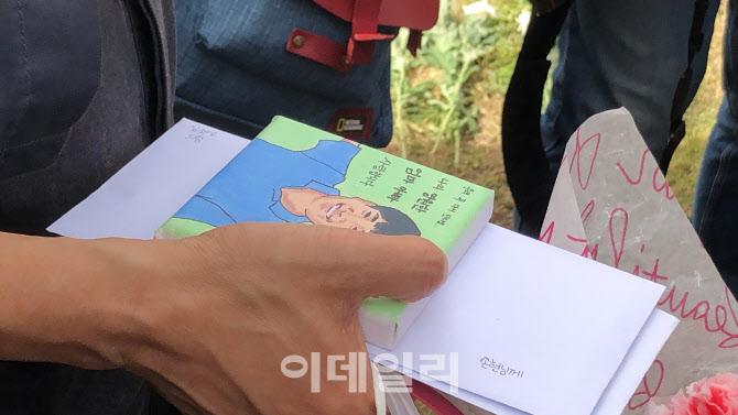 故·ソン·ジョンミンさんの生前の絵が市民から父親にプレゼントされる場面