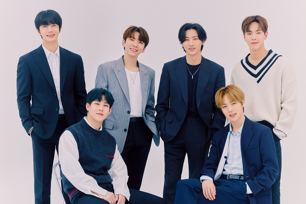 MONSTA X 團體照，成員們穿著正式西裝，以專業風格亮相，展現其成熟魅力。背景為簡單的白色。