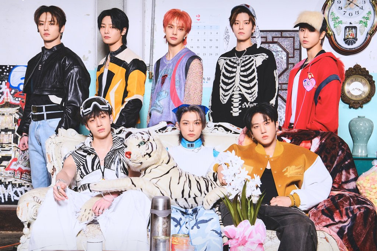 Stray Kids 團體宣傳照，成員們穿著多彩的休閒服裝，在裝飾有趣的室內場景中坐著，呈現出活力四射的氛圍。
