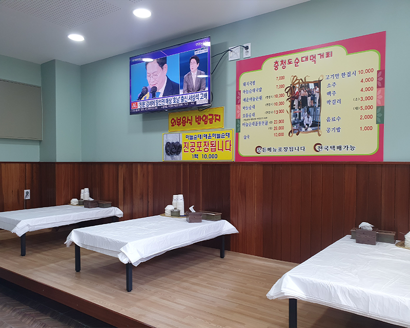 忠清道丹陽のスンデ専門店の店内にある座敷のスペース、壁にはメニューと顧客への提示メッセージが掲示されている。
