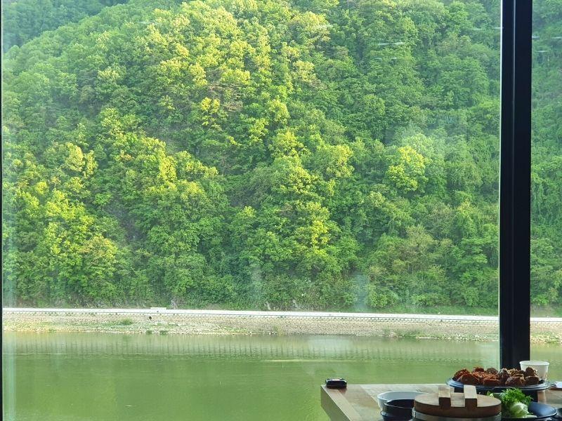 View of the river and mountain next to the table at Dawon Restaurant Danyang