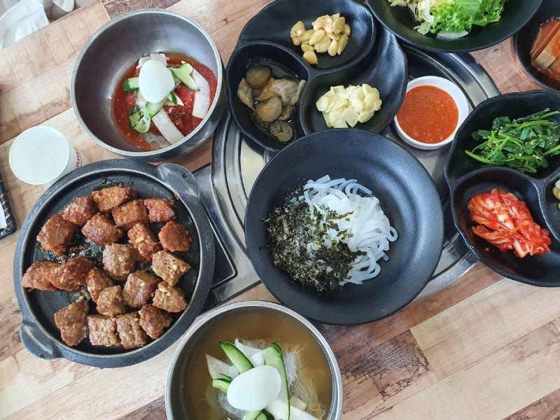 table of tteok-galbi, cold noodles, and Korean side dishes at Dawon Restaurant Danyang