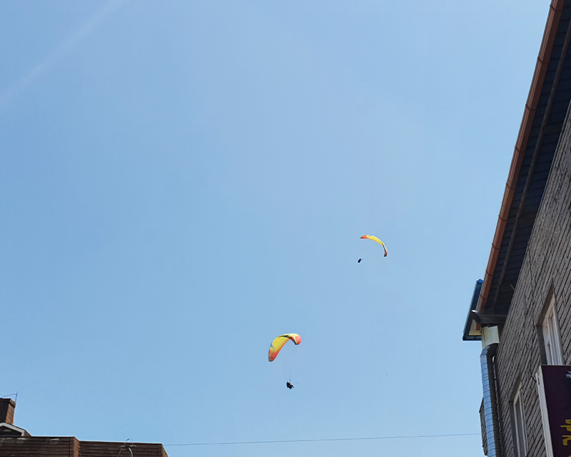 People paragliding in the sky at Danyang Gugyeong Traditional Market
