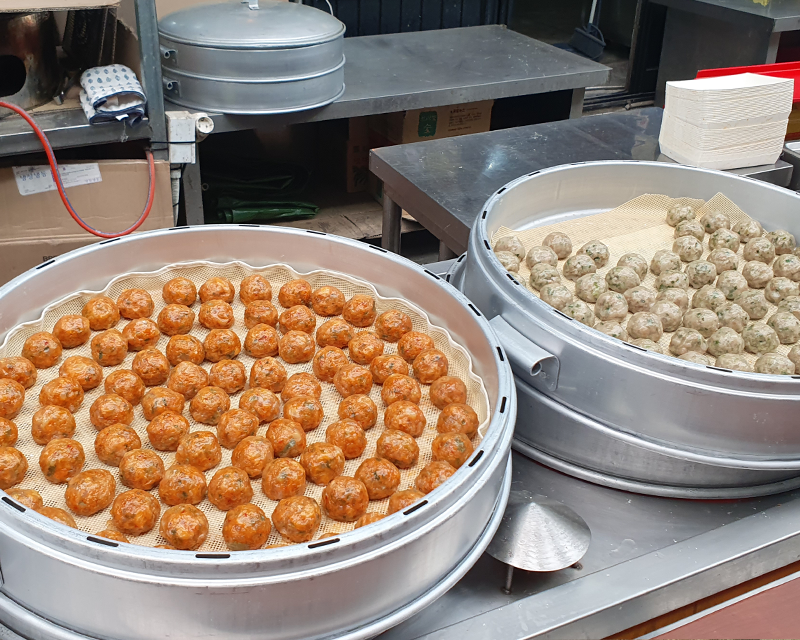 クギョン市場の食品コーナー。丸い形の料理が蒸し器に並んで蒸されている様子。