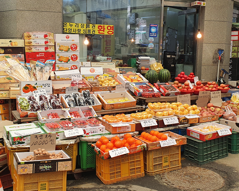クギョン市場の青果店。色とりどりの新鮮な果物が詰まれた箱が並ぶ。
