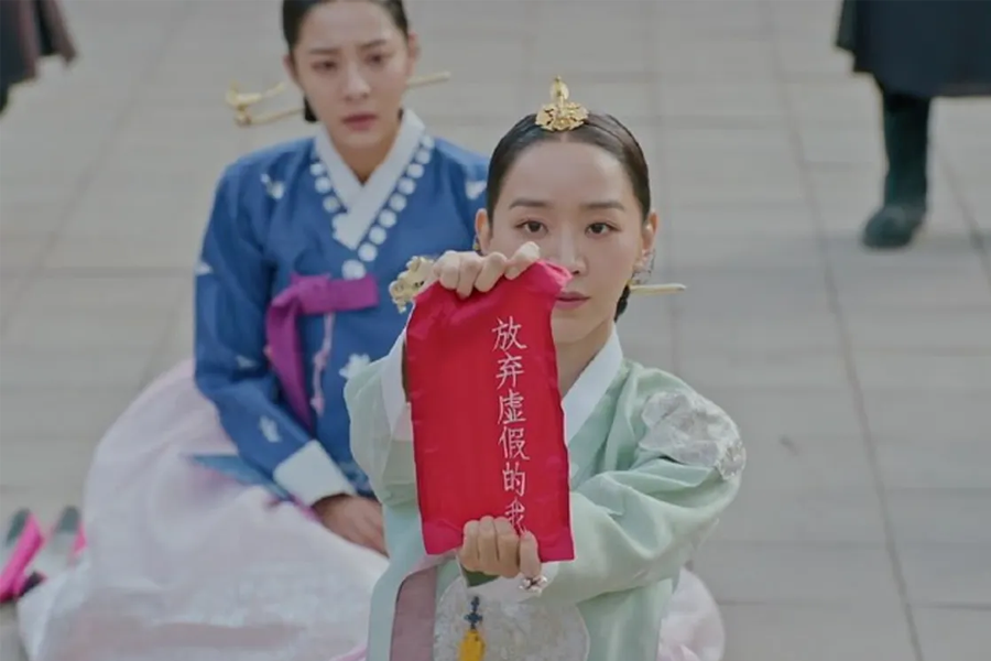 一名角色坐在地上，身穿韓服，高舉著一面紅色的布袋，上面寫著中文。這個場景出自韓國古裝劇《哲仁皇后》，其中的中文使用看似未符合劇中的時代背景，成為劇中一個值得注意的穿幫場景。