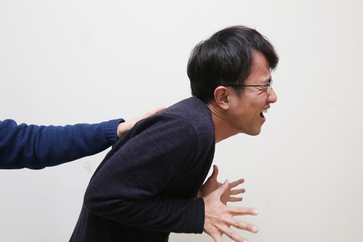 描繪一位施力於他人身上的圖像，反映韓語諺語手辣（손이 맵다）之含義。