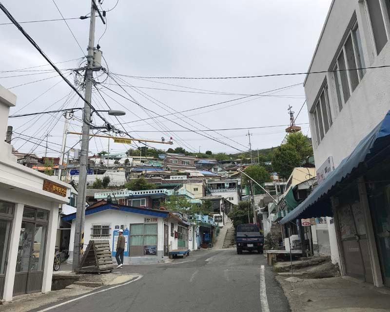 木浦詩畫村的街道，電線交錯的空中，兩旁是住宅和商店，展現當地的日常生活氛圍。