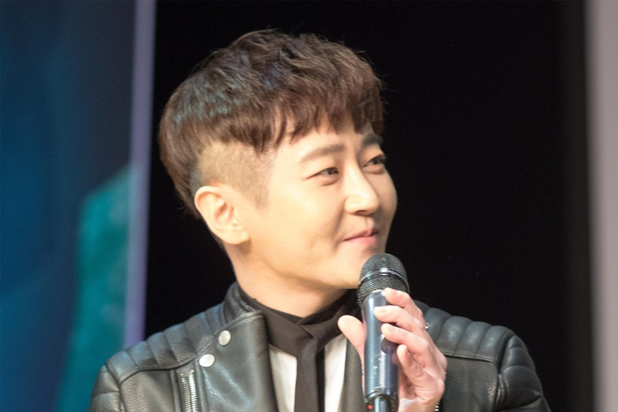 韓國樂團M.C the MAX成員之一在現場演出，身著皮夾克，手持麥克風。