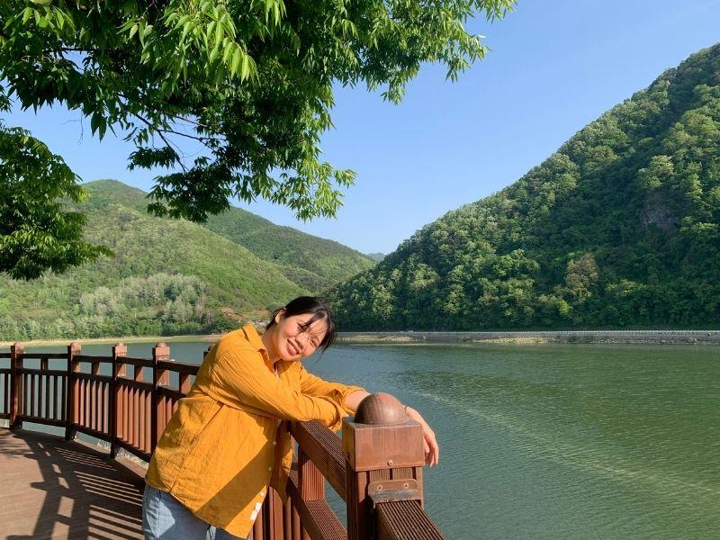 creatrip editor posing on boardwalk with river and mountains in background at rose tunnel in danyang south kores