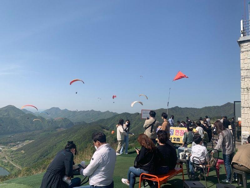 view of people and paragliders from cafe sann in danyang south korea