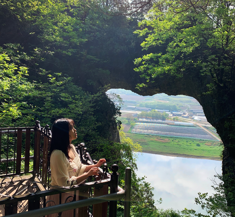 creatrip editor posing on look out deck with stone gate (seongmun) and namhan river  in background in danyang south korea