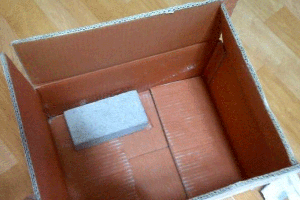 ダンボール箱にレンガが1つ入っている写真。この写真は中古取引詐欺の事例を象徴しており、購入を決めた商品が実際にはレンガにすり替えられて送られてきたことを示しています。