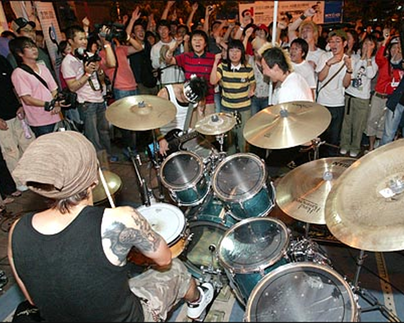 crowds of people cheering drummer playing at night club in hongdae seoul south korea