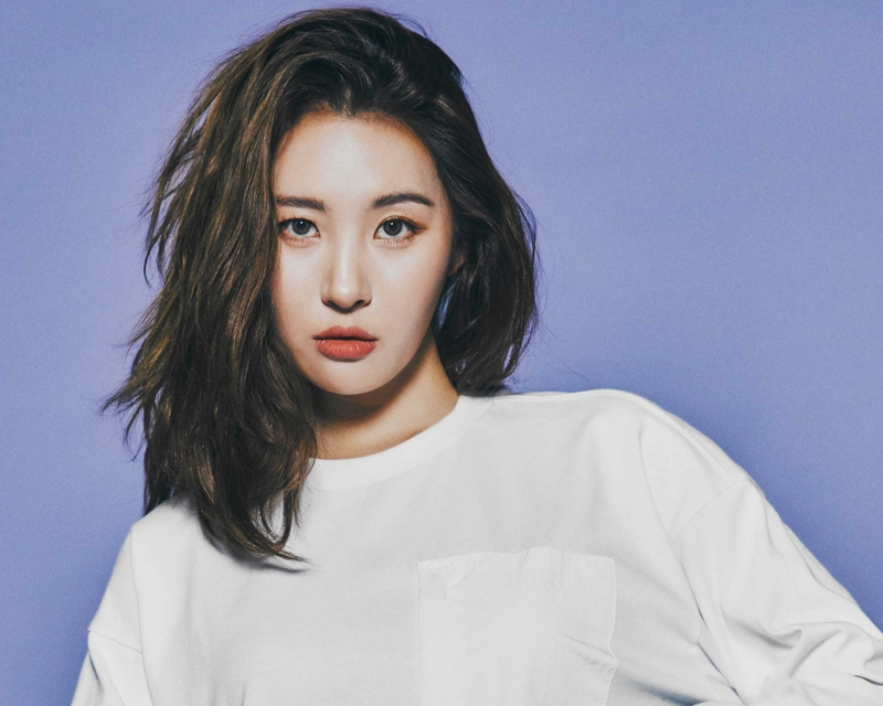 韓國藝人宣美的照片，背景紫色，穿著簡約風格白色上衣。