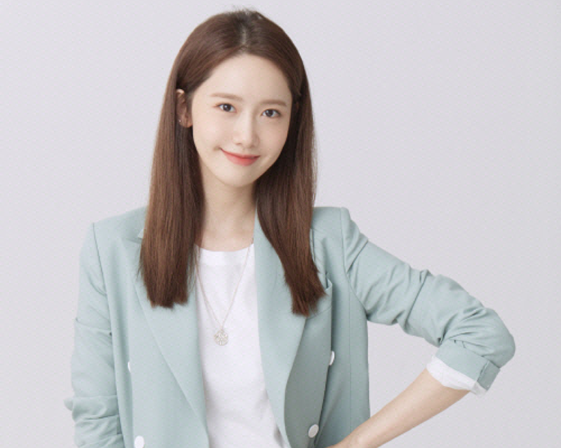 韓國藝人潤娥的照片，身穿綠色西裝，背景為白色。