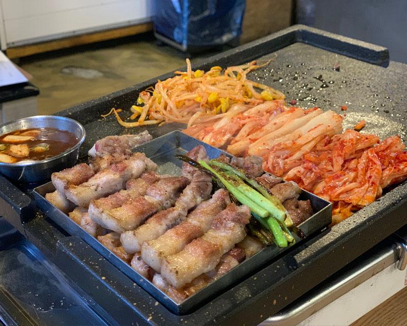 kim chi và giá đỗ được nhân viên nướng trong nhà hàng DONJUDA Hàn Quốc