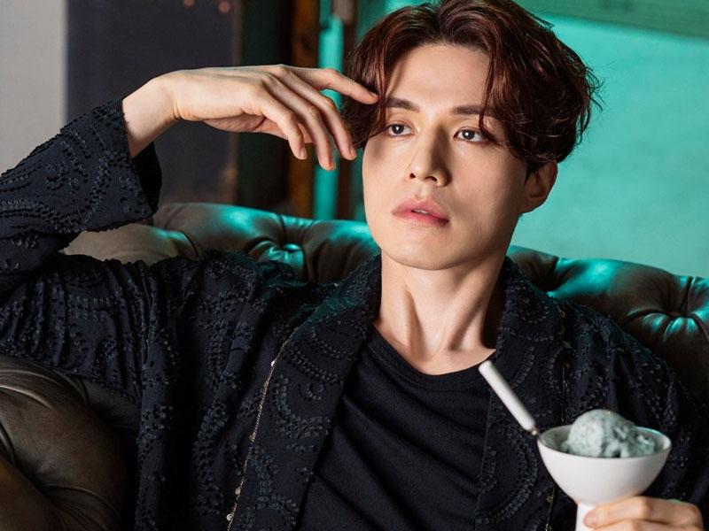 บุคคลนั่งบนโซฟาถือไอศกรีมมิ้นต์ช็อกโกแลตในมือข้างหนึ่ง