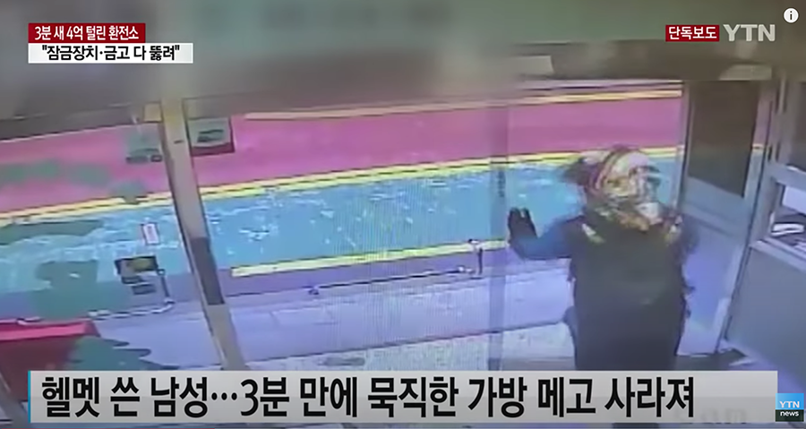 男子從大樓走出，監視器拍下他戴著頭盔的身影，大樓的出入口是他進出的地方。此畫面與犯罪時間一致。來源：YTN (臺灣譯文: 男子走出大樓入口，監控拍到他戴著頭盔的形象) 