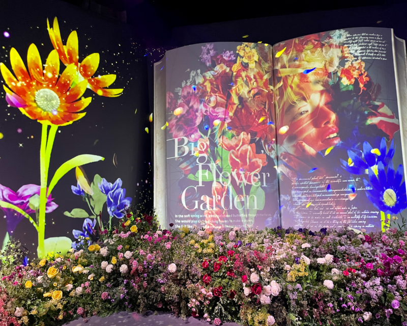 La zona 'Big Book' di Flowers By Naked Hongdae con fiori colorati e immagini in movimento.