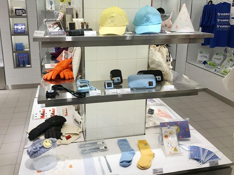 YG Store中展示著各類日常用品如帽子、錢包和襪子的商品貨架。