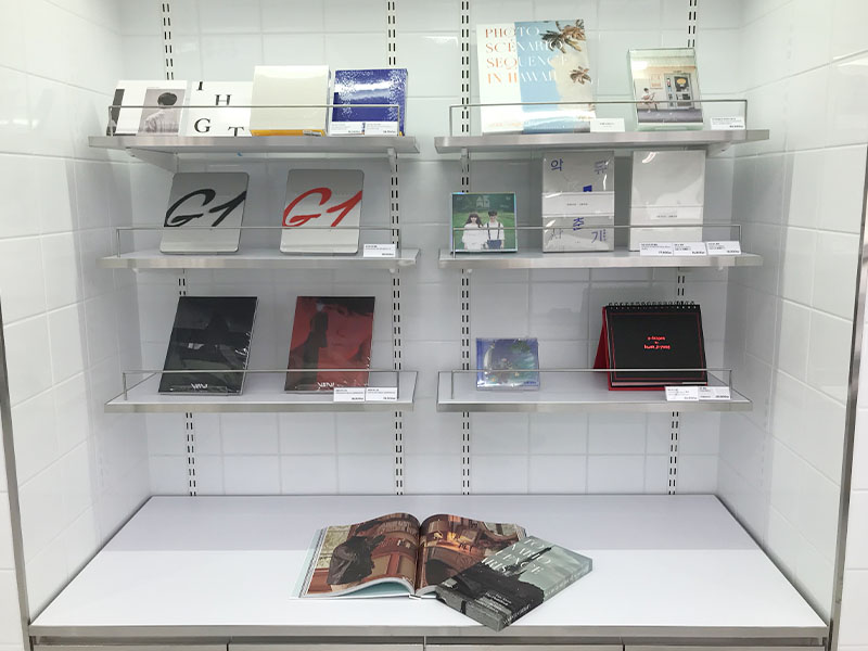 merchandise on display on white shelves at YG the SameE cafe