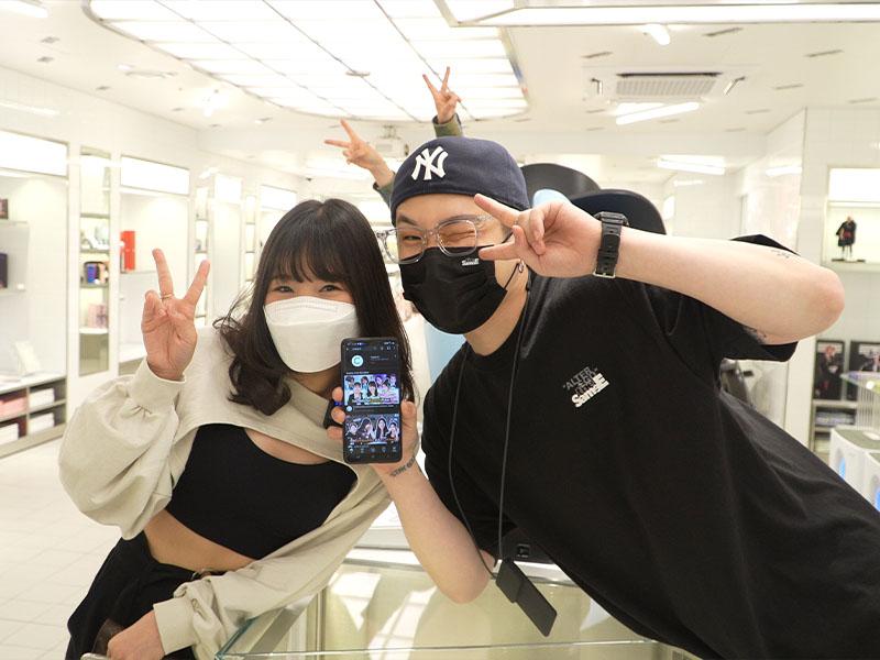 Girl next to staff member at YG the SameE cafe