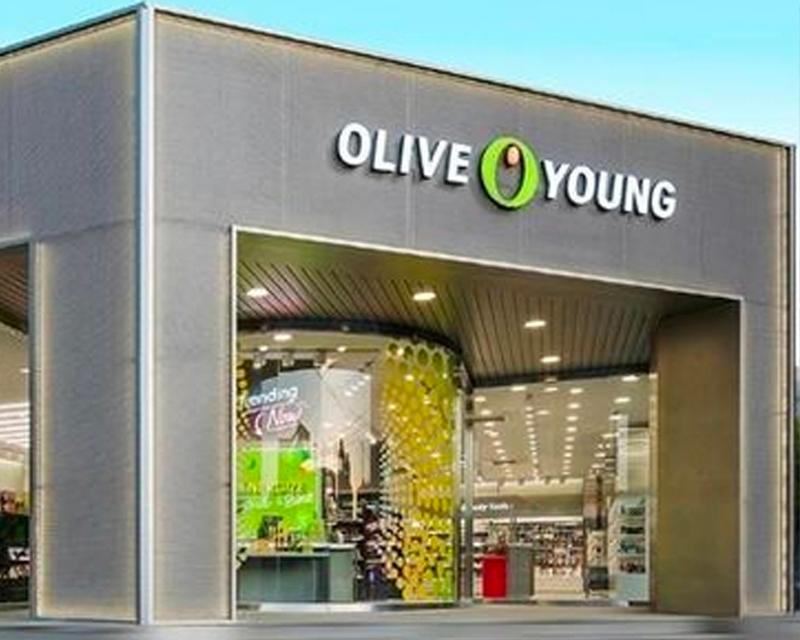 Olive Young店面入口，顯示出這家韓國大型連鎖藥妝店的招牌和現代化設計。
