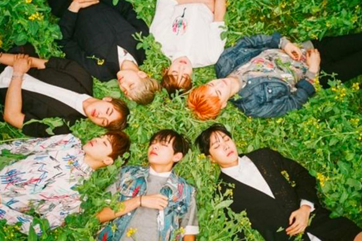 BTS members lying on grass in a circle, showcasing a serene and youthful vibe, related to their '청춘 삼부작' series.