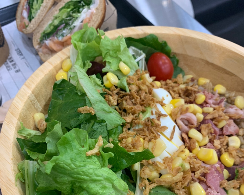 closeup on salad with greens, corn, ham, and egg from korean franchise salady