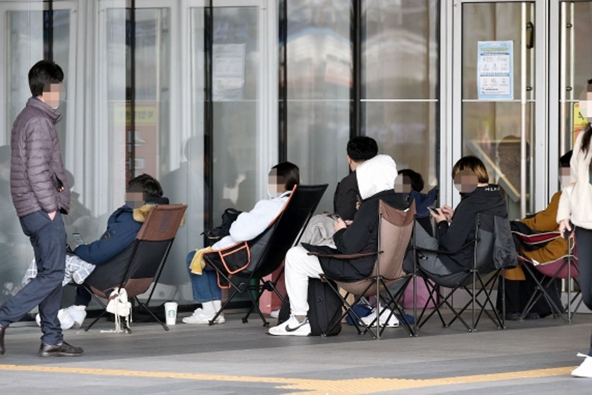 為名牌店開門候位的青年