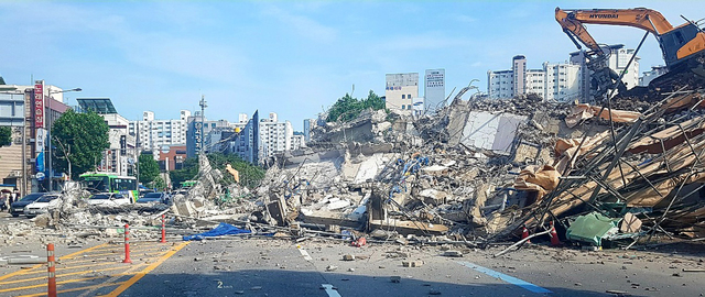 光州大樓倒塌後的現場,顯示倒塌的建築物大片瓦礫堆和毀壞的道路外觀。