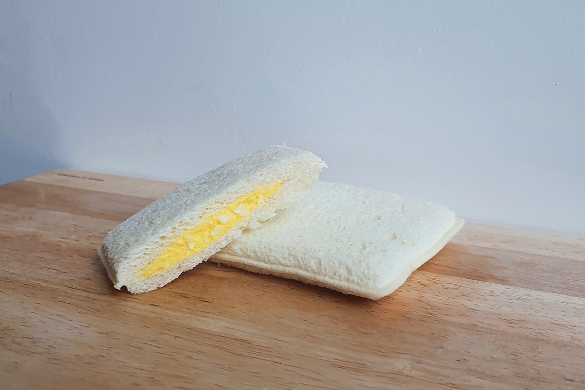 Egg Mayo Pocket sandwich from GS25 cut in half on a wooden tray