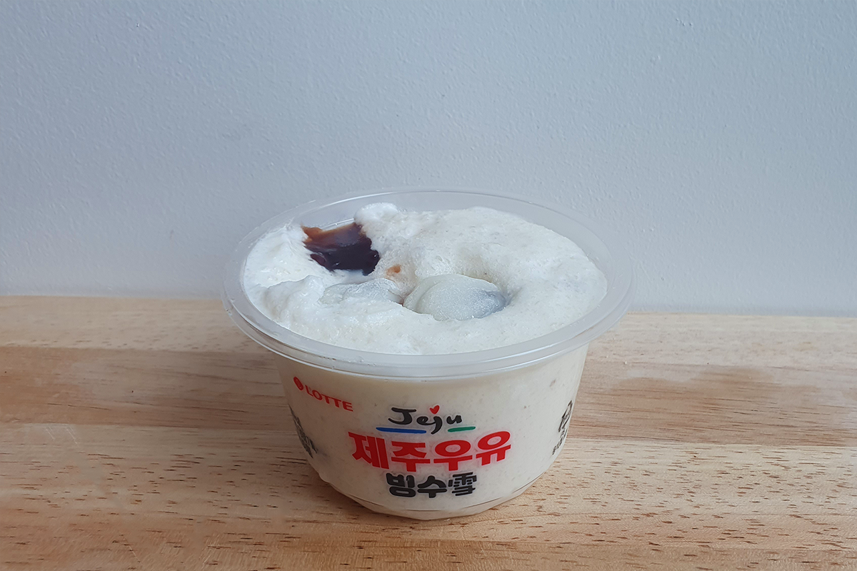 打開的濟州牛奶刨冰，中間放着小圓飯糰，如軟綿綿的雲朵。