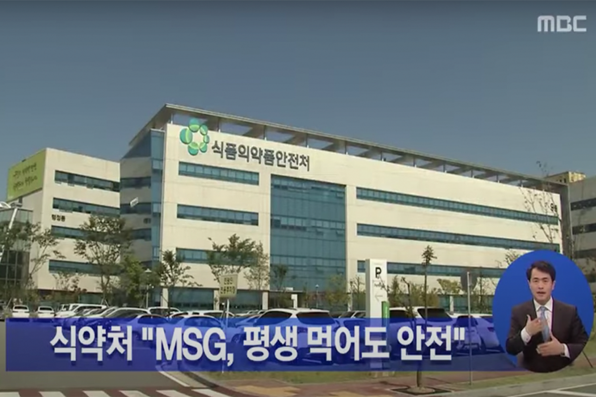 韓國食品醫藥品安全廳的建築物正面視圖，標示著味精被認為終生食用也安全的新聞標題，提供對味精的正確認識。