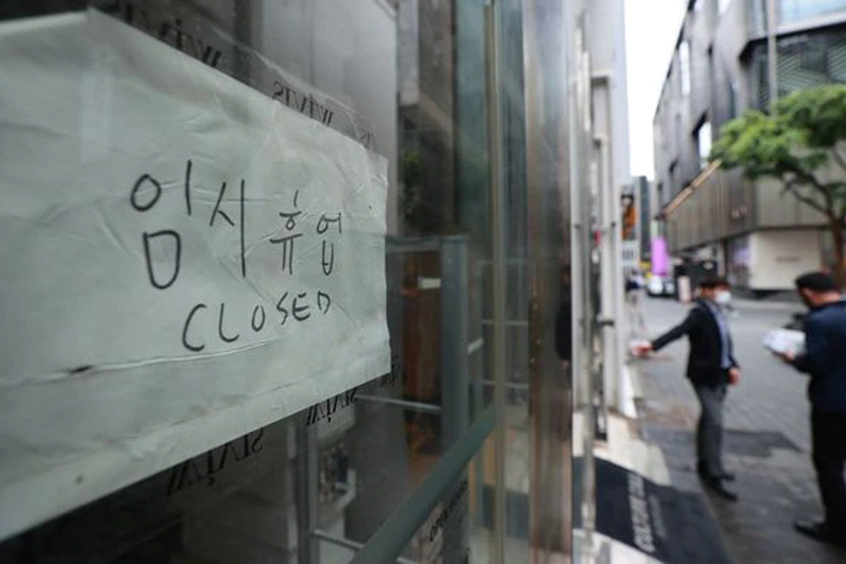 一張韓國商店臨時休業的照片，紙上寫著閉店與 'Closed' 字樣