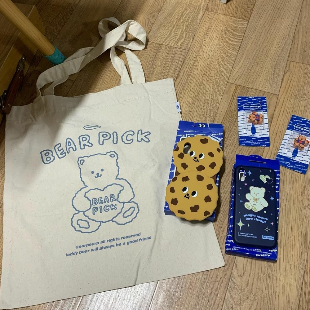 Sac pour Earpearp, accessoires pour téléphone disposés sur le sol en bois