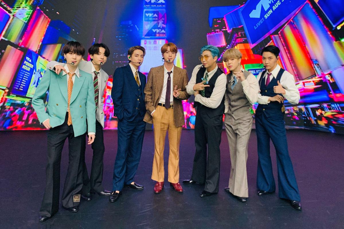 BTS成員在《Dynamite》MV拍攝的霓虹燈背景中，著華麗的70年代風格服裝。