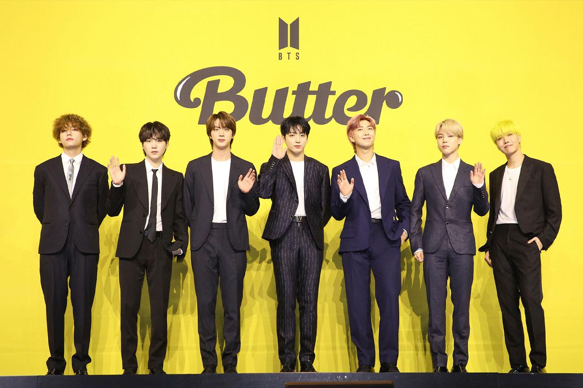 BTS成員在亮黃色背景前參與《Butter》發布會，他們穿著正式的西裝。