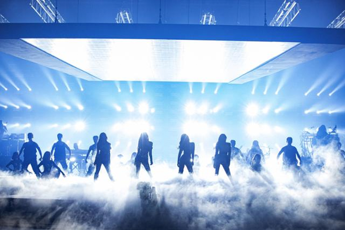 BLACKPINK 成員喺舞台表演期間，以炫目燈光為背景。