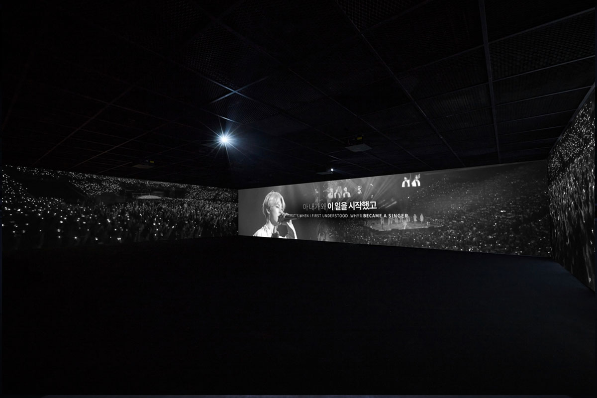 Image of video featuring Kpop group BTS being projected on three walls
