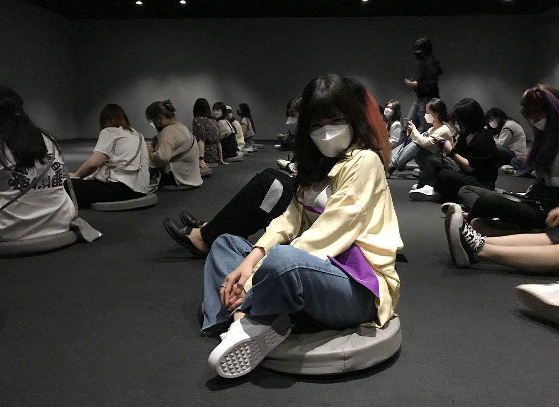 Visitors sitting on seat cushions in screening room