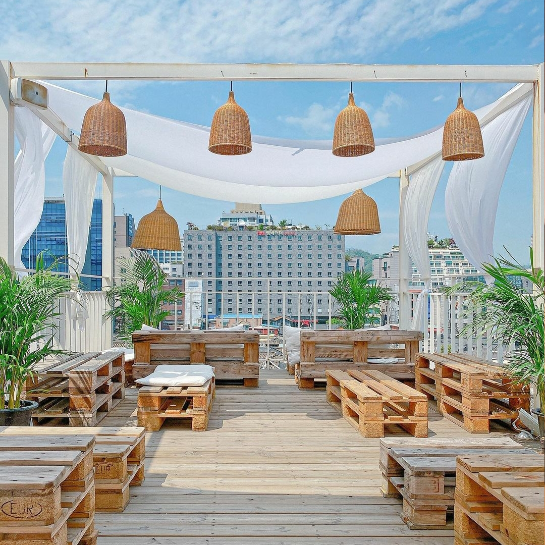 wooden chairs and tables on the rooftop of Hotel Seine