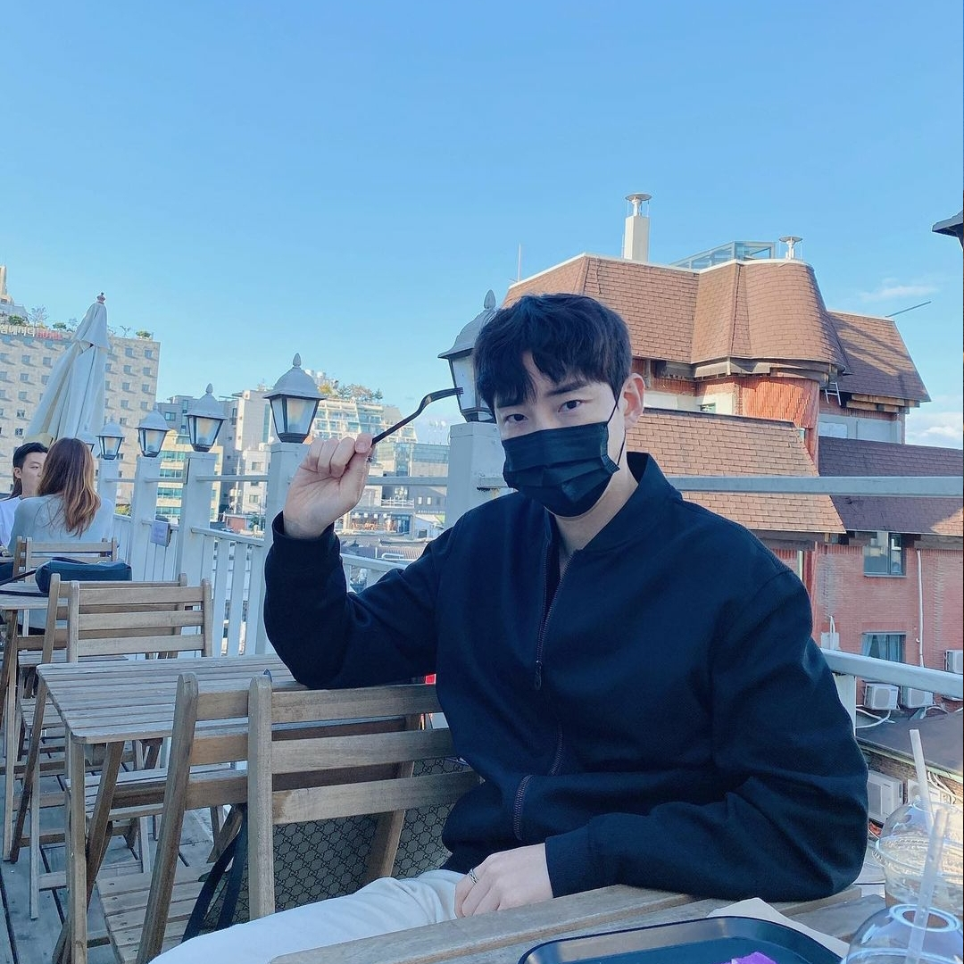 Korean man sitting on the wooden chair at the rooftop of Hotel Seine