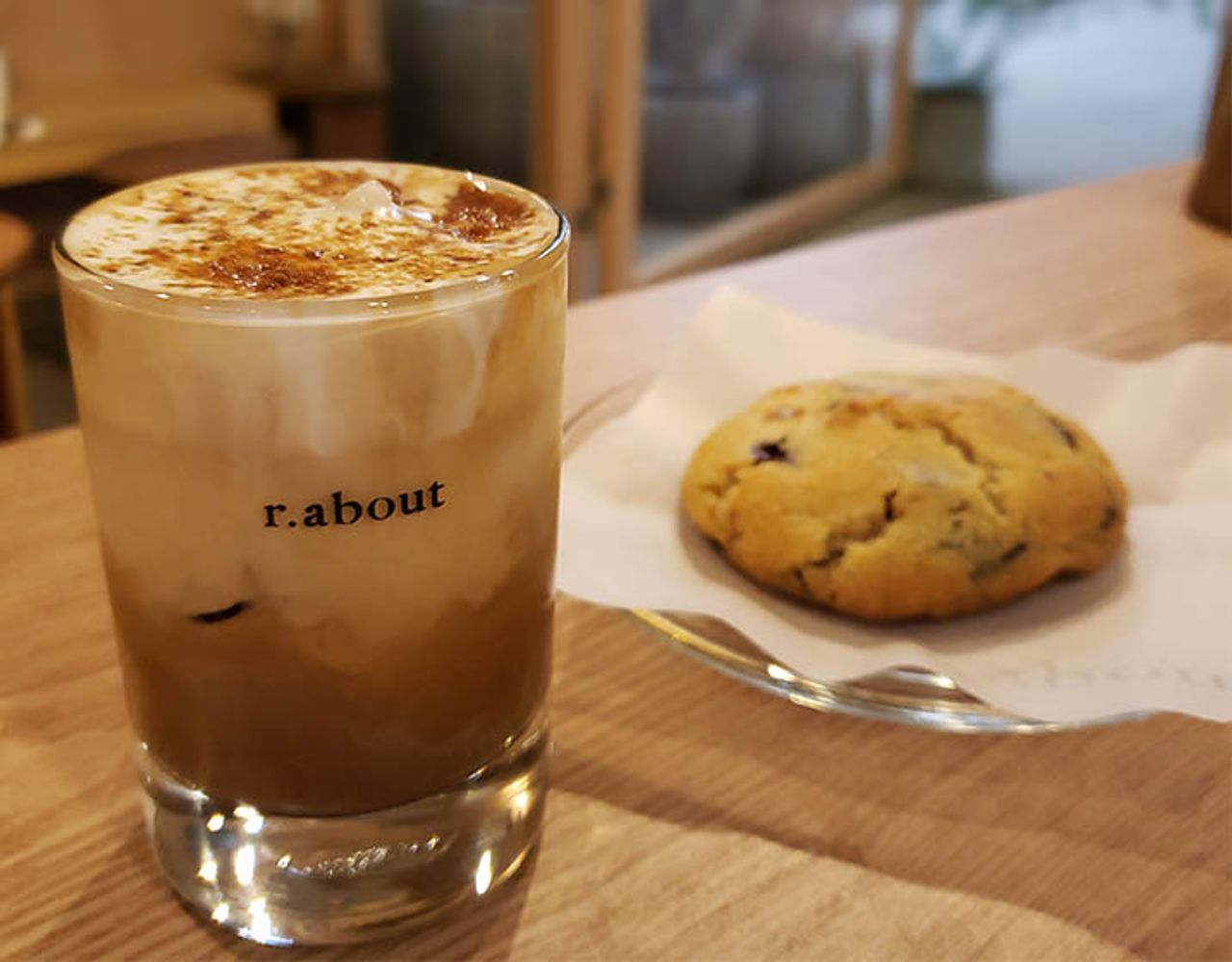 Segelas kopi dan kue di Cafe r.about di Garogolmok, Seoul.